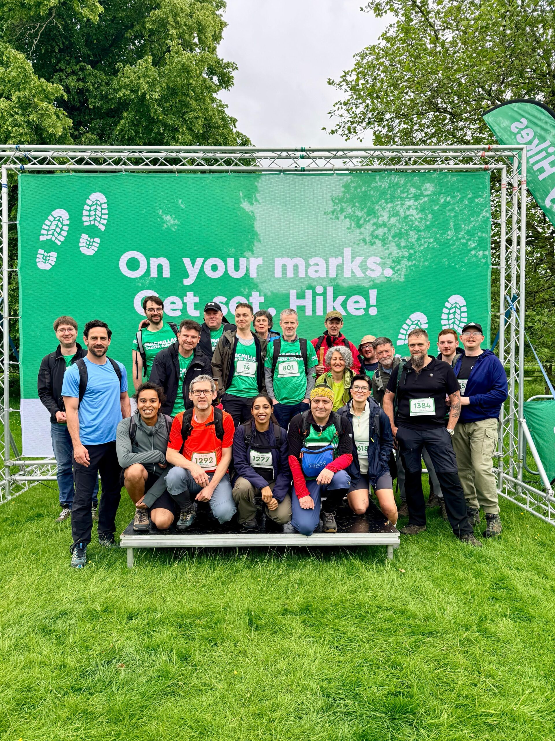 Group poses at Mighty Hike event, "On your marks. Get set. Hike!" banner